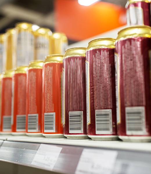 sale and alcohol concept - close up of beer or cider cans at liquor store